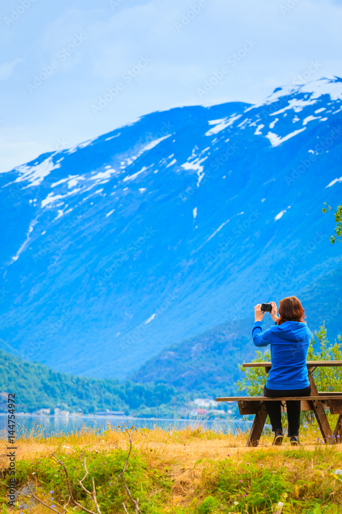 Tourist taking photo at norwegian fjord Tourist taking photo at norwegian fjord