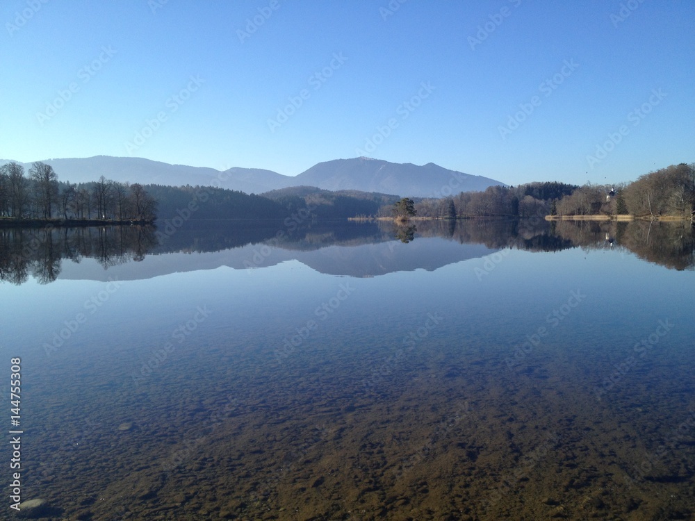 Impressing lake view with perfekt reflection of landscape in the Staffelsee near Murnau in Germany