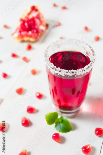 Pomegranate drink in glass with sugar decoration
