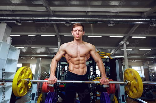 Male athlete with a barbell in the gym.