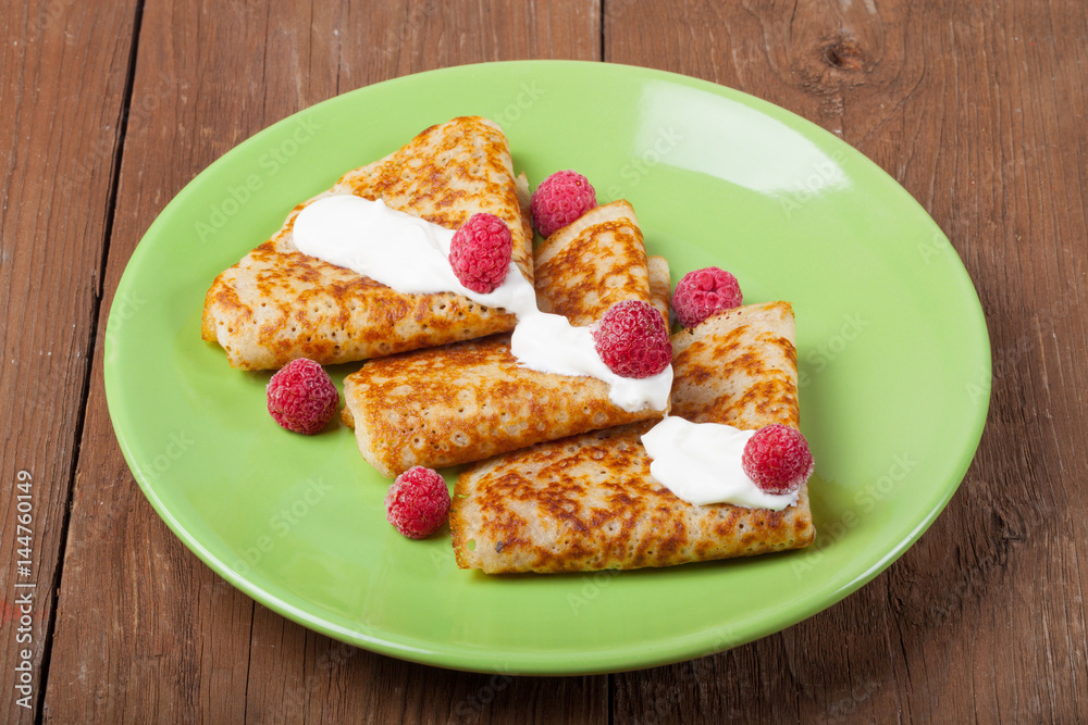Russian pancakes - blini with sour cream topping. Selective focus Russian pancakes - blini with sour cream topping. Selective focus