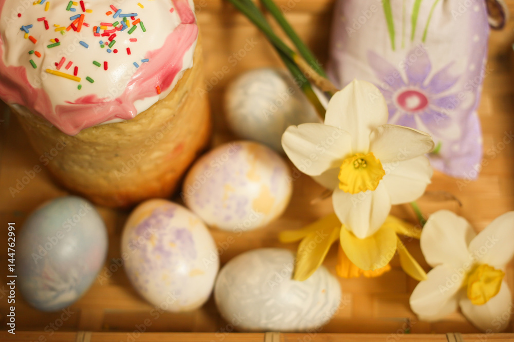 Easter cake and decoration eggs with daffodils on table Easter cake and decoration eggs with daffodils on table