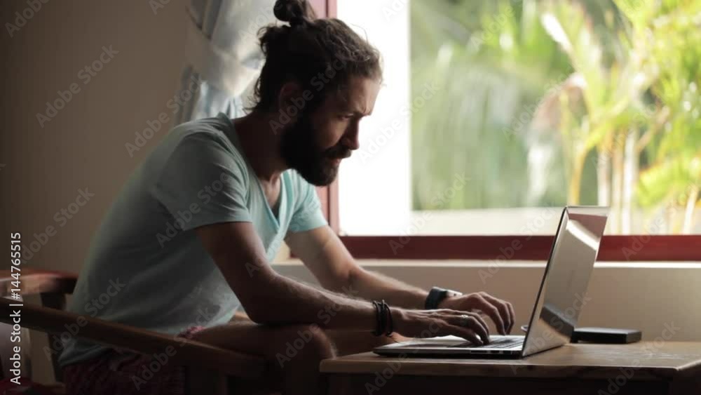 Young man finish working on laptop and lean back on chair