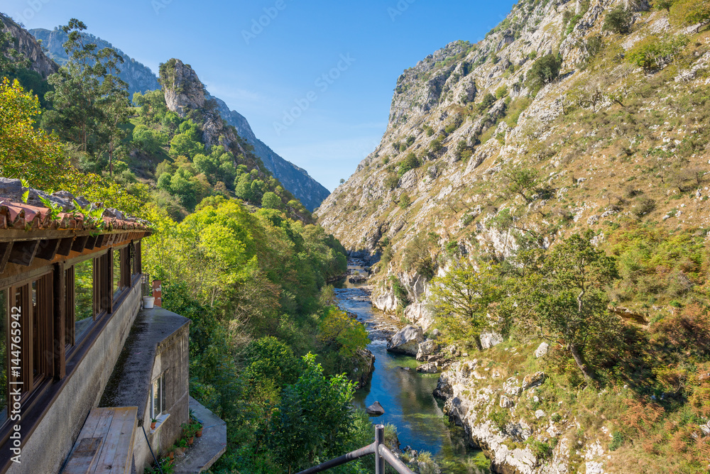 The mountain stream Rio Cares runs through the valley in the foothills of the National Park Picos de Europa. Also the foothills are a popular hiking destination and leads along the Camino de Santiago