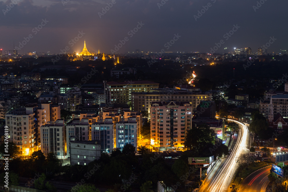 Fototapeta premium Widok Yangon, Myanmar, od above w wieczór. Podświetlona Pagoda Shwedagon znajduje się w oddali.
