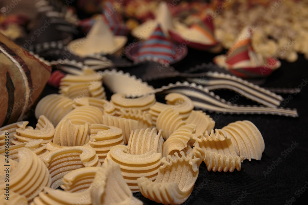 Uncooked Ruled and Curved Italian Pasta on Black Table