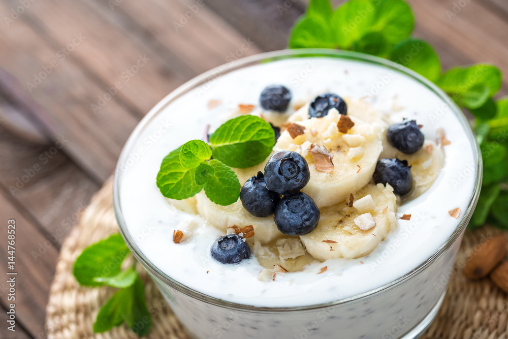 Yogurt with fresh blueberry, banana and almond nuts, delicious dessert for healthy breakfast Yogurt with fresh blueberry, banana and almond nuts, delicious dessert for healthy breakfast