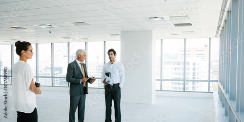 Real estate agent talking with clients inside an empty office sp