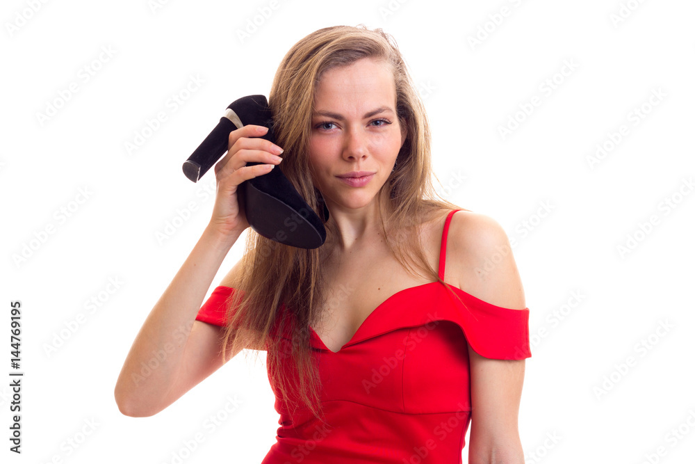 Young woman in red dress holding shoes Young woman in red dress holding shoes