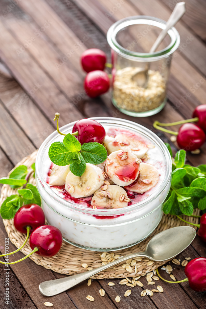 Fresh yogurt with cherry, banana and oats, delicious dessert for healthy breakfast Fresh yogurt with cherry, banana and oats, delicious dessert for healthy breakfast