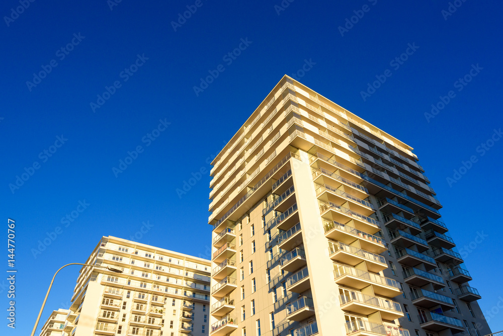 Modern apartment block with balcony against a blue sky. Modern apartment block with balcony against a blue sky.