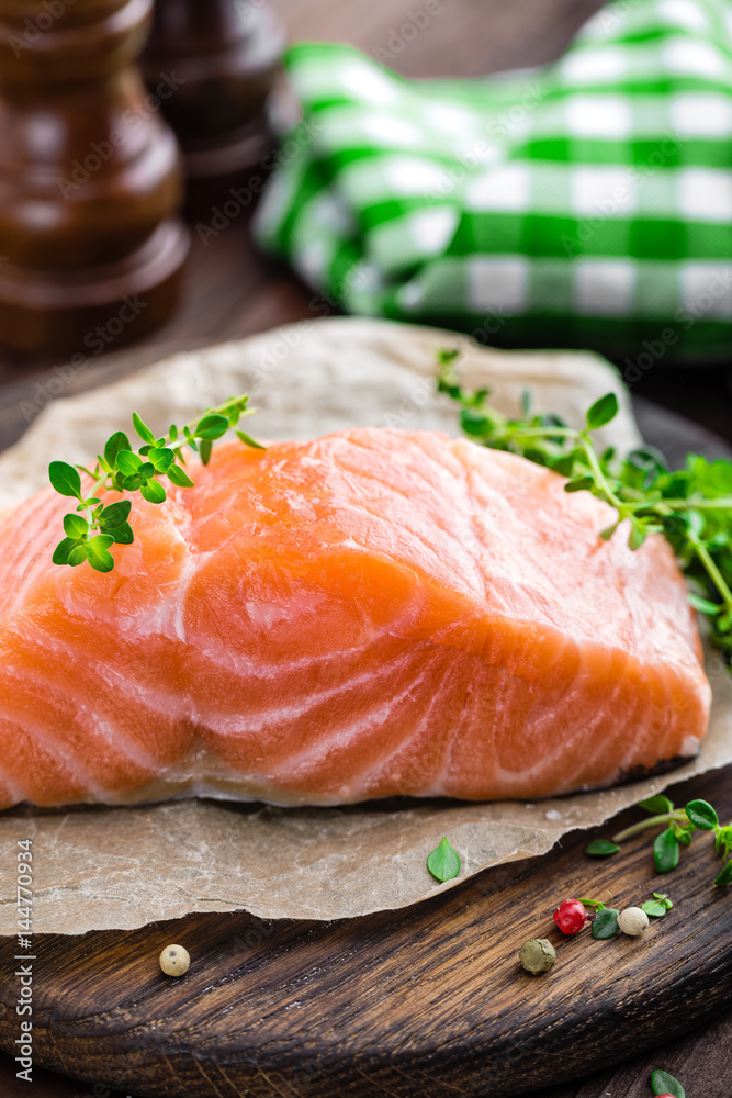 Raw salmon fish fillet on wooden board closeup Raw salmon fish fillet on wooden board closeup