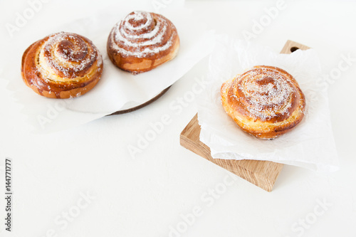 Sweet rolls with sugar and cinnamon on white background.