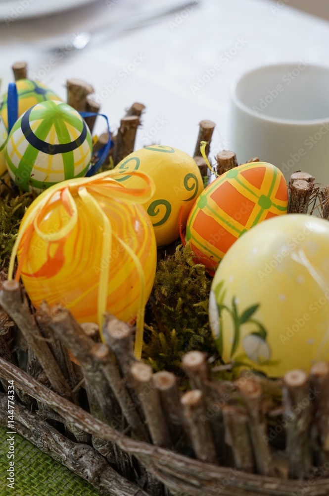 Fototapeta premium Ostern: Dekoration mit bunten Ostereiern und Blumen