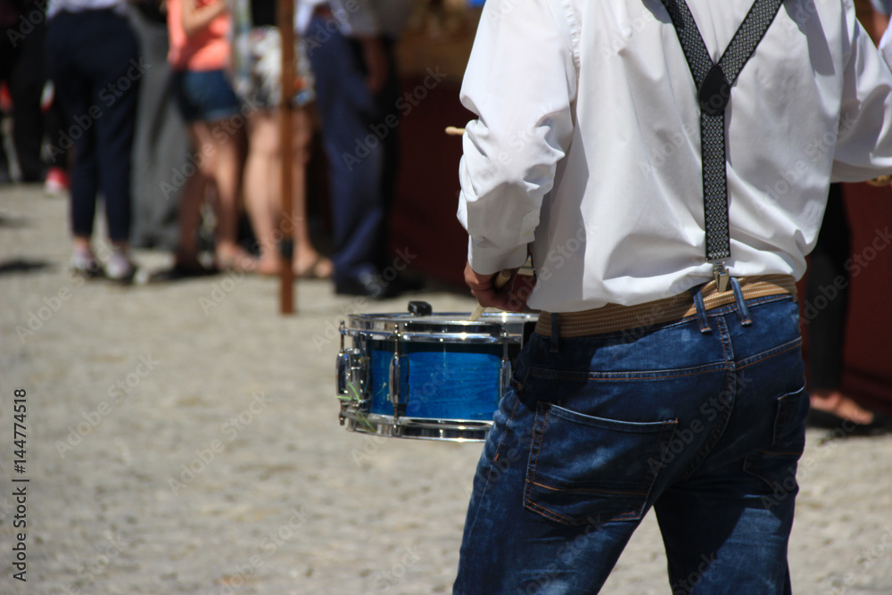 Man playing the drum with a street music group
