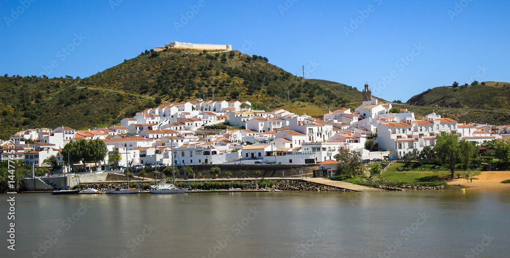 View of the village of Sanlucar on the banks of Guadiana river located in Spain taken from Alcoutim in Portugal. April 2017