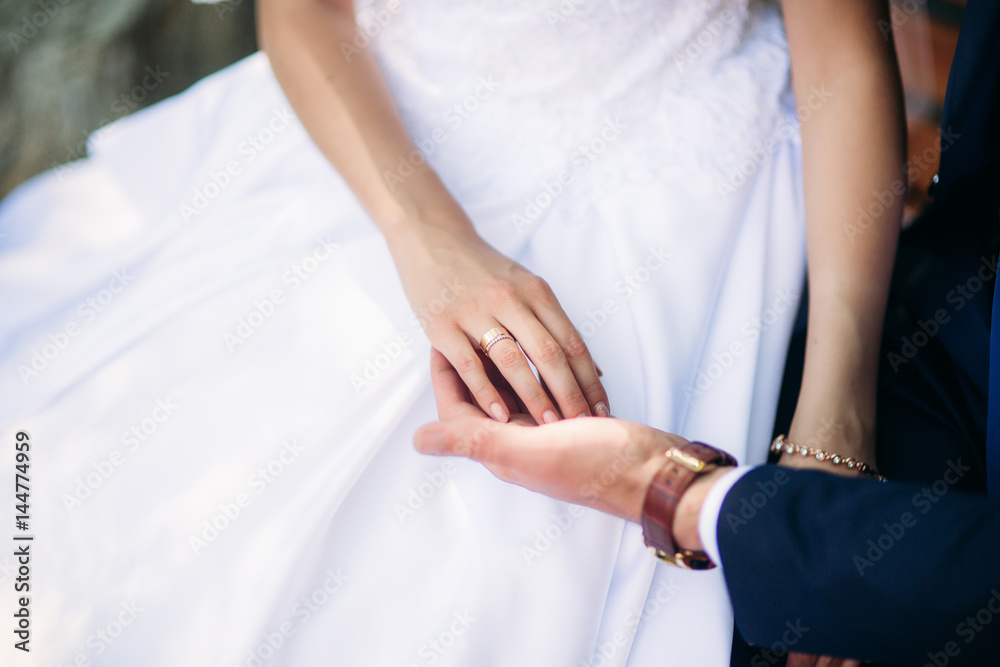 Beautiful couple walking in the park in their wedding day. Sunny weather.