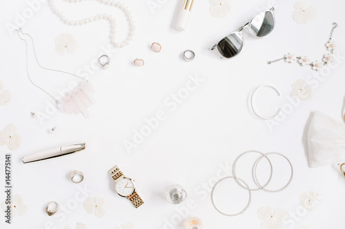 Beauty blog frame concept. Woman clothes and accessories: watches, sunglasses, bracelet, necklace, rings, lipstick on white background. Flat lay, top view trendy fashion feminine background.