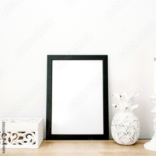 Front view blank mock up of photo frame with pineapple and trendy stuff at white background. Minimalistic decorated home office concept.