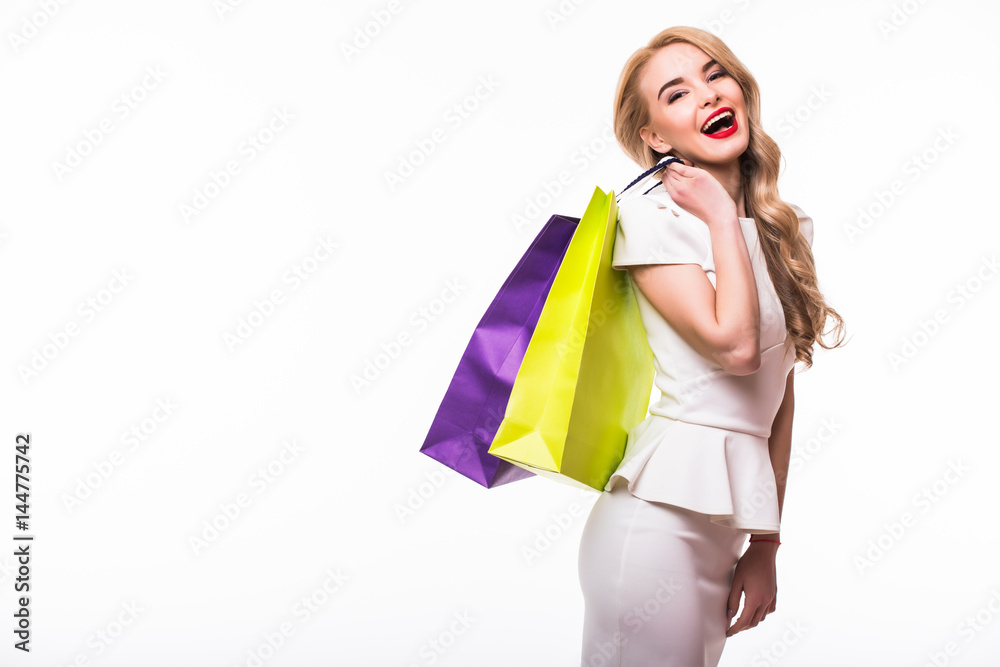 Portrait of an young woman holding several shoppingbag on white background.