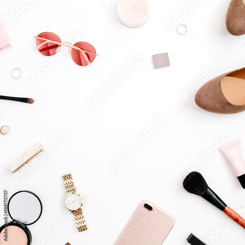 Beauty blog fashion frame concept. Female pink styled accessories: mobile phone, watches, sunglasses, cosmetics, shoes on white background. Flat lay, top view trendy feminine background.
