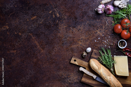 Sandwich cooking ingredients. French baguette with cheese and vegetables over rustic counter top. View above, copy space.
