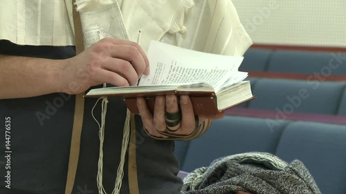 jewish man putting tefillin and pray photo