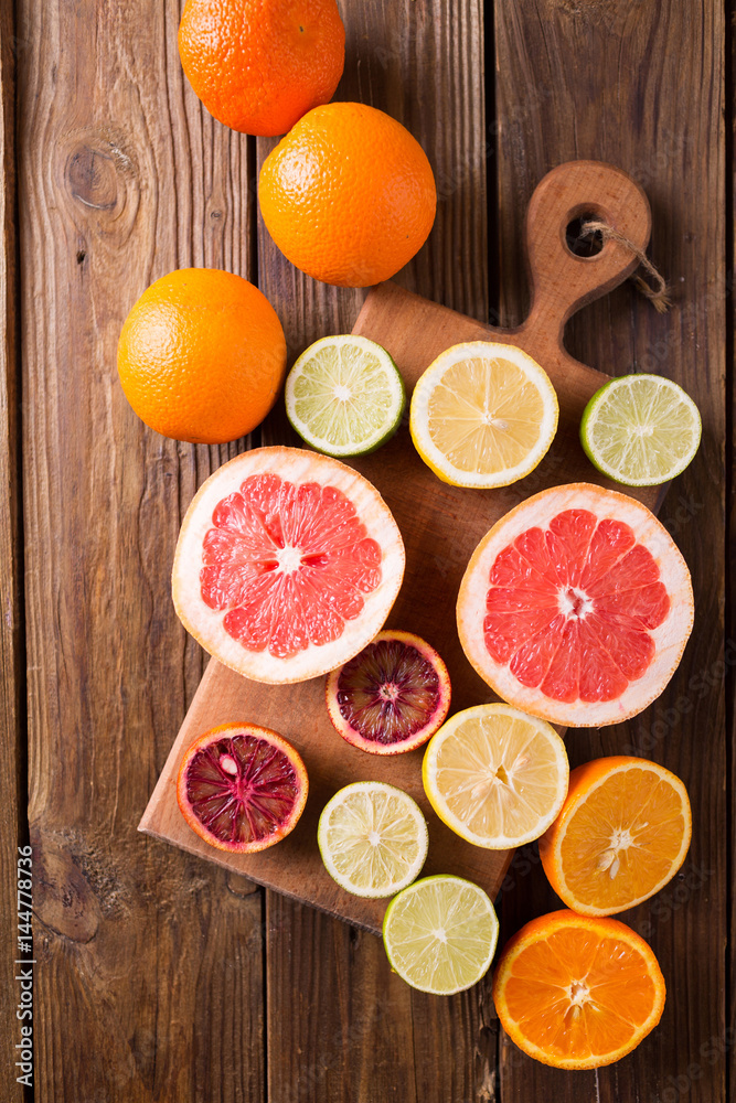 Citrus fruits on a wooden background. Оrange, lemon, grapefruit, mandarin, lime. Mixed festive colorful tropical and citrus fruit sliced. Healthy eating photo concept. Copyspace Citrus fruits on a wooden background. Оrange, lemon, grapefruit, mandarin, lime. Mixed festive colorful tropical and citrus fruit sliced. Healthy eating photo concept. Copyspace