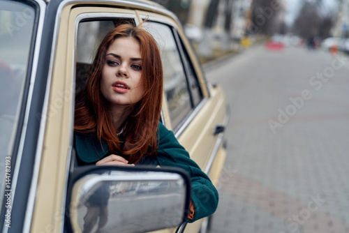 woman looks out of the window of the car side window rear view