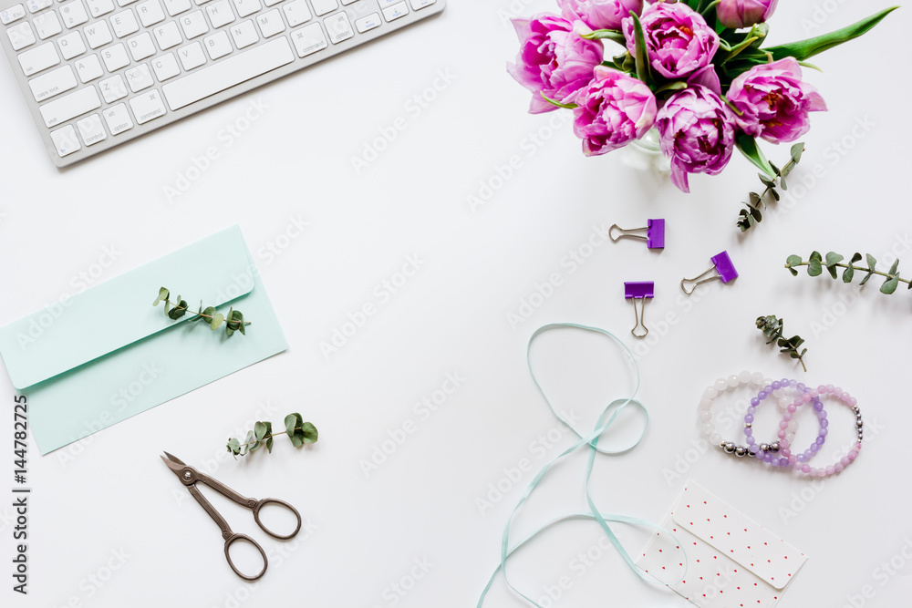 Spring flowers on workdesk at home white background top view mockup Spring flowers on workdesk at home white background top view mockup
