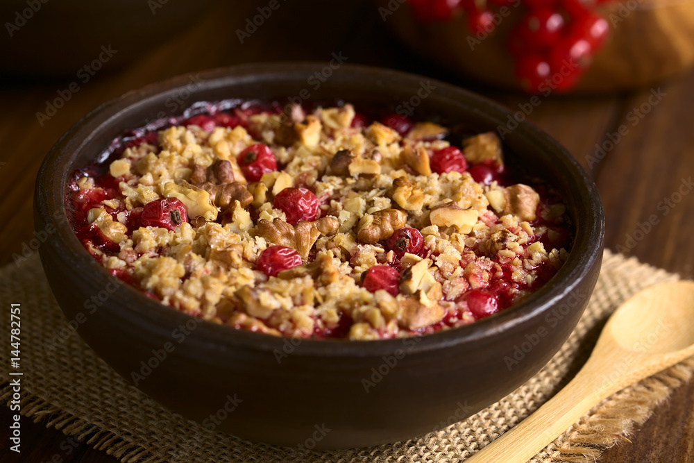 Johannisbeeren Crumble oder Crisp, ein gebackener Johannisbeeren Dessert mit Haferflocken und Walnuss Streusel, fotografiert auf mit natürlichem Licht (Selektiver Fockus) Johannisbeeren Crumble oder Crisp, ein gebackener Johannisbeeren Dessert mit Haferflocken und Walnuss Streusel, fotografiert auf mit natürlichem Licht (Selektiver Fockus)