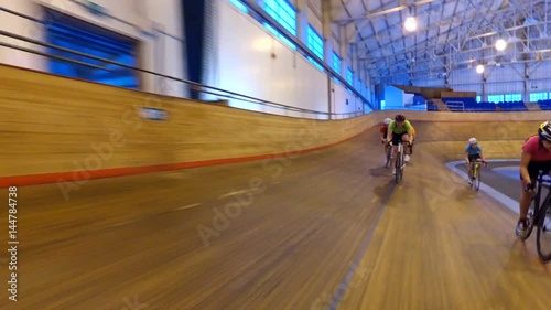  Action tracking shot of competitive cyclists racing on track in velodrome photo