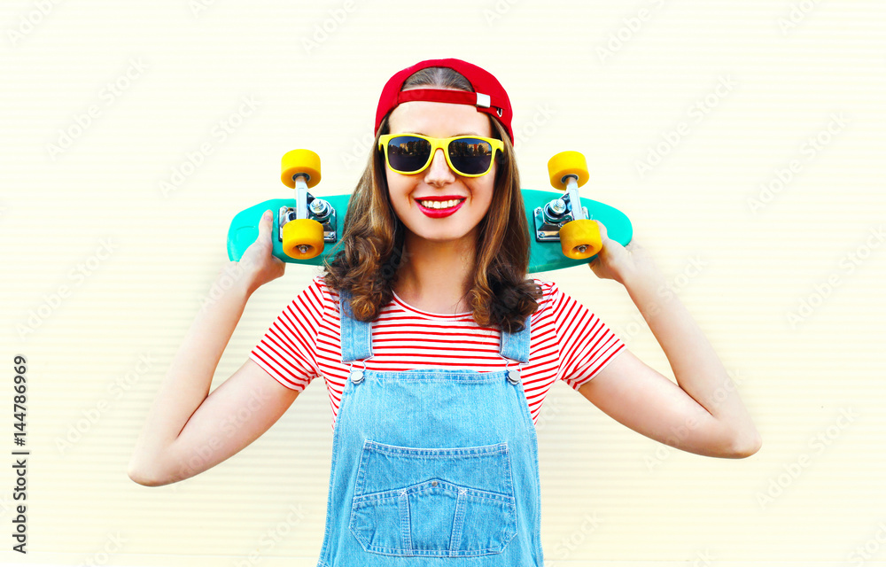 Fashion cool girl smiling with skateboard over white background Fashion cool girl smiling with skateboard over white background