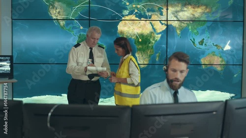  Security & surveillance team working in system control room. Could be a meteorological weather station or airport traffic control room. 