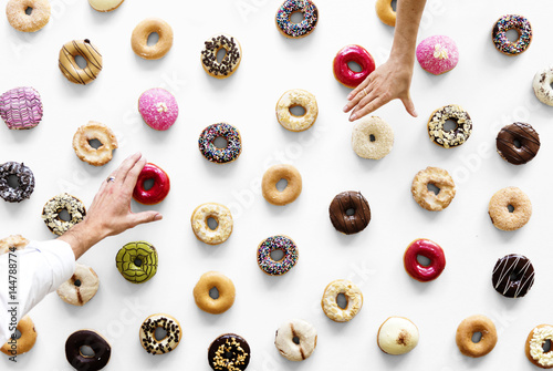 Hands selecting a variety of donut flavour photo