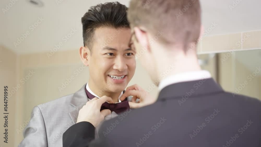 Young gay couple getting ready for wedding day share a kiss Young gay couple getting ready for wedding day share a kiss