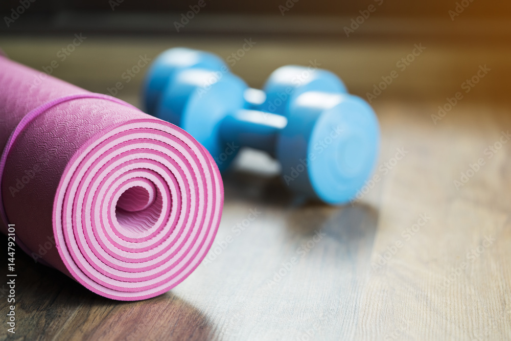 dumbbell and yoga mat on wood table dumbbell and yoga mat on wood table