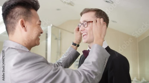  Young gay couple getting ready for wedding day share a kiss photo