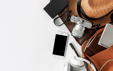 Top view of essential modern. travel accessories on white wooden table background. over light 