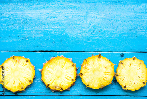 the summer pineapple is slice for eat on blue wooden background. copy space for designer