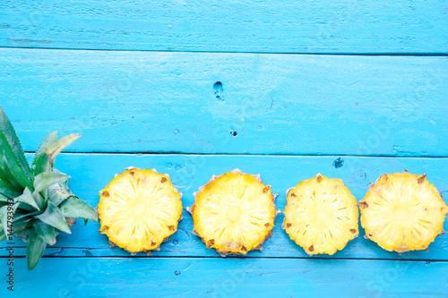 the summer pineapple is slice for eat on blue wooden background. copy space for designer