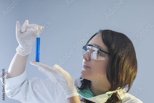 Female Laboratory Assistant Holding One Flask in Hand During Scientific Experiment.