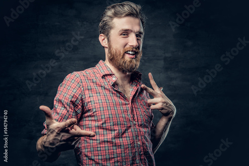 Bearded male dressed in a red fleece shirt makes conversation. photo