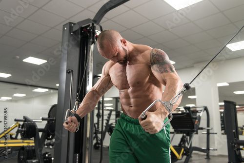 Man Doing Exercise For Biceps On Cable Machine