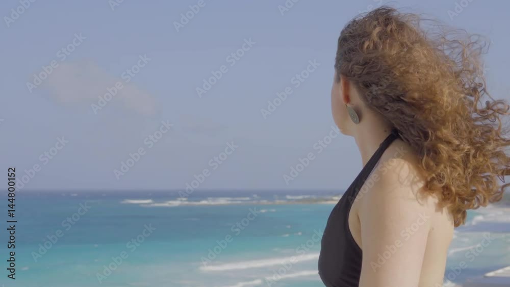 Profile of beautiful womans looking out on windy beach Profile of beautiful womans looking out on windy beach