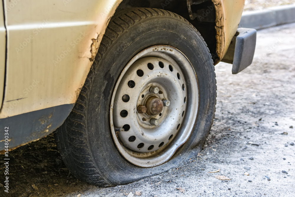 Flat tire of an old car on road Flat tire of an old car on road