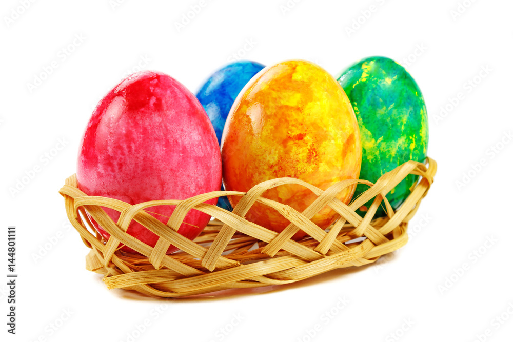 Obraz premium Colored Easter eggs in basket on white background