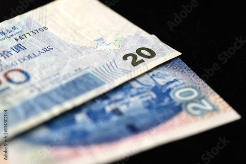 Two bills of twenty Hong Kong dollars on a dark background