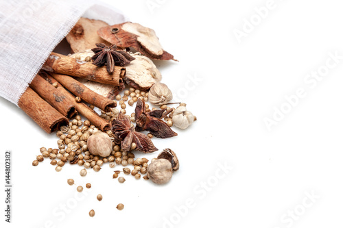 Obraz na płótnie Chinese spices blend : cinnamons, star anises, galanga, best cardarmom and coriander seeds in white bag on white background isolated with copy space w salonie