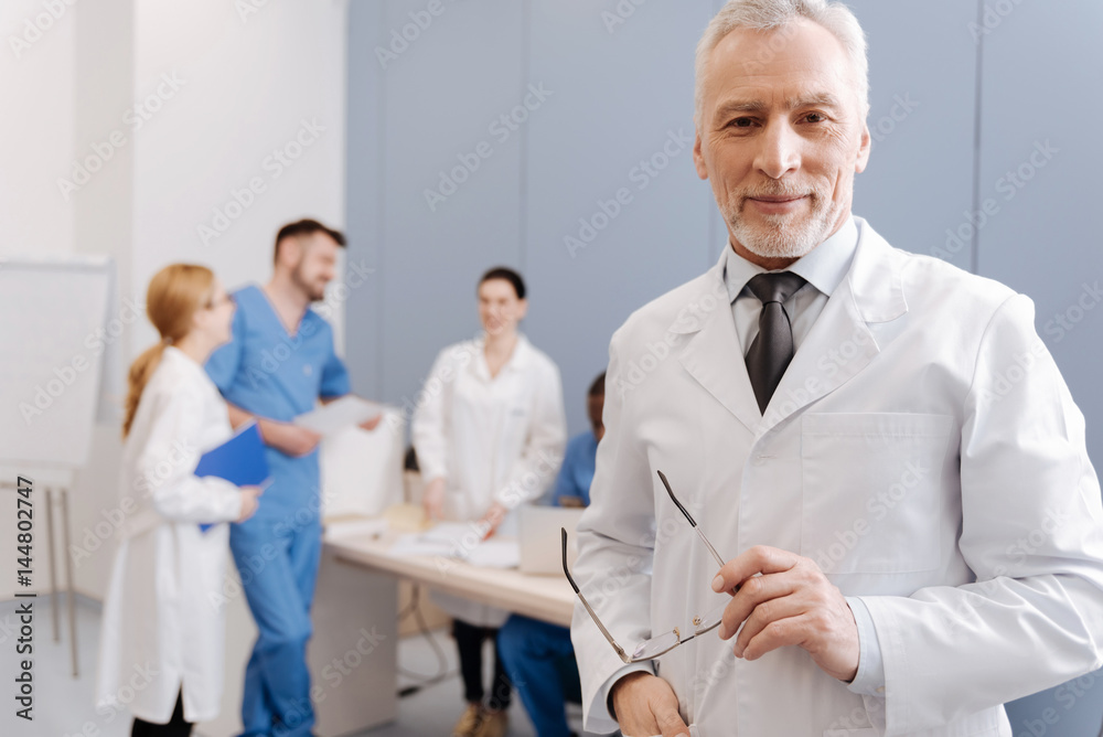 Cheerful aged doctor conducting medical conference in the clinic Cheerful aged doctor conducting medical conference in the clinic